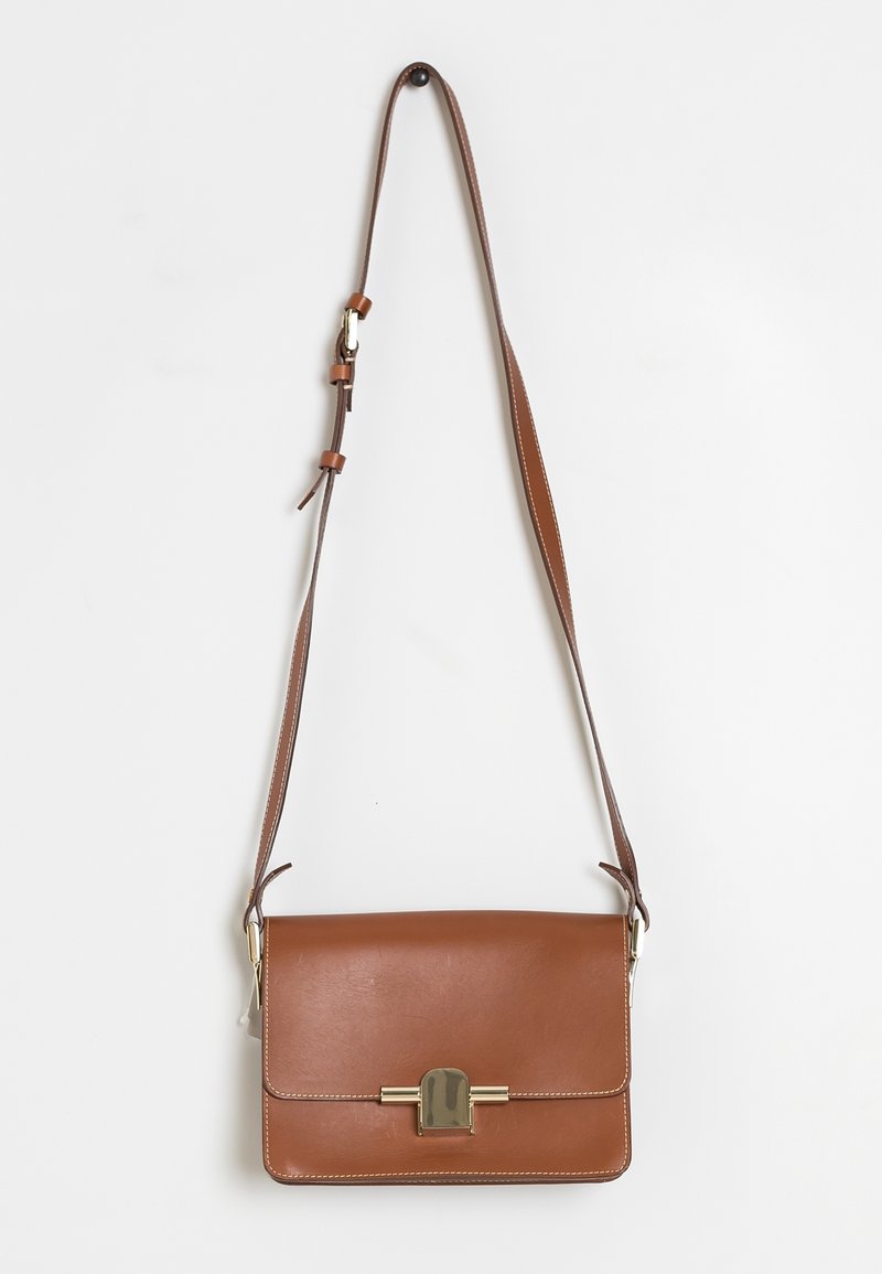 Brown leather crossbody bag with a flap closure, gold-tone hardware, and adjustable strap. Textured finish with contrasting stitching details.