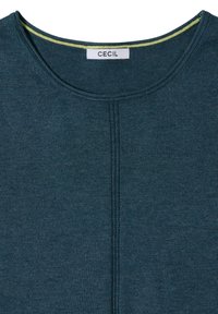 Haut en maille bleu sarcelle foncé avec encolure ronde et couture verticale au centre devant, avec une petite étiquette blanche comportant la mention "CECIL" à l’intérieur du col.