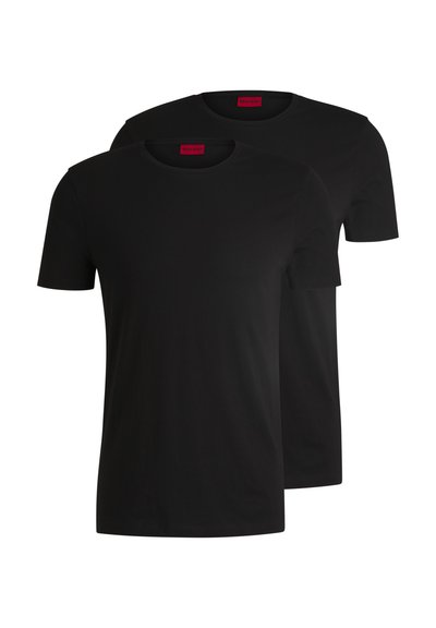 Deux t-shirts en coton noirs à manches courtes et col rond. Tous deux présentent une étiquette de marque rouge au niveau du cou. Design simple et classique.