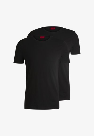 Deux t-shirts en coton noirs à manches courtes et col rond. Tous deux présentent une étiquette de marque rouge au niveau du cou. Design simple et classique.