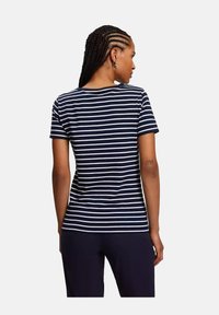 Granatowo-biała, pasek T-shirt z krótkimi rękawami, okrągłym dekoltem i luźnym krojem, wykonany z miękkiego, oddychającego materiału.