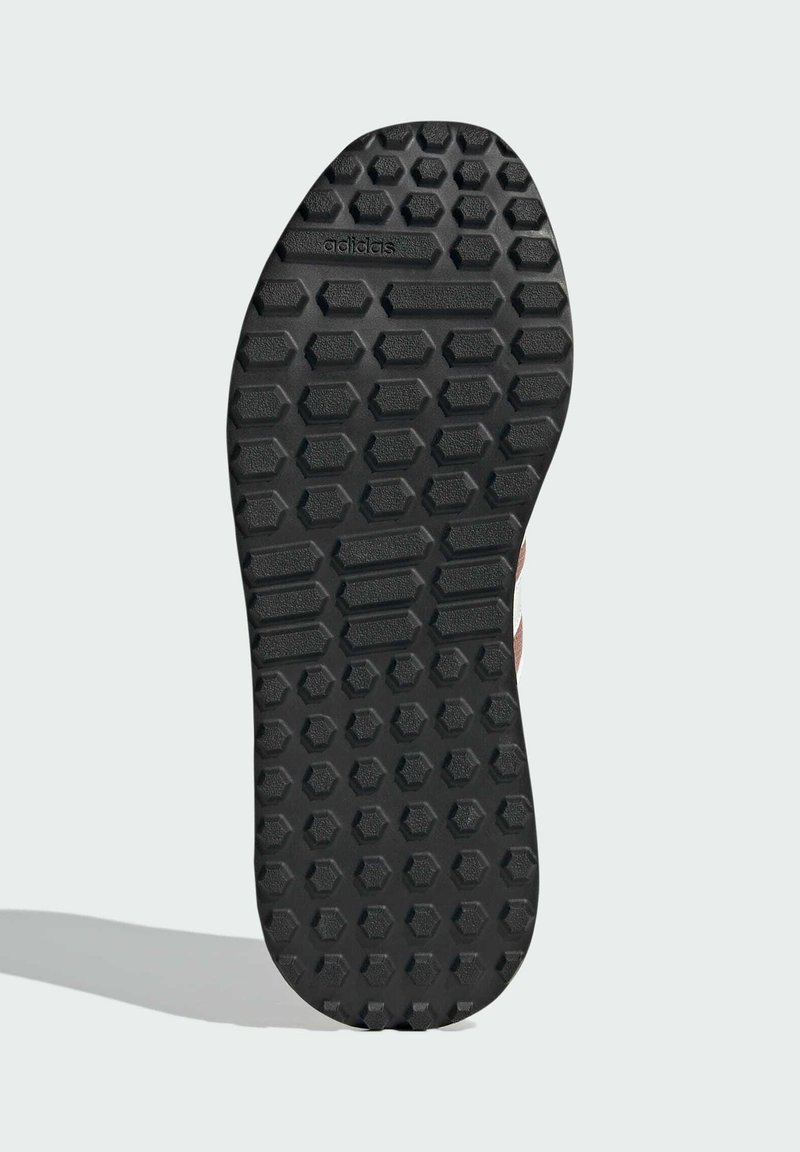 Schwarze Gummisohle mit hexagonalen Mustern, versehen mit dem eingeprägten "adidas"-Logo auf der Oberfläche. Glattes und robustes Design, ideal für Grip.