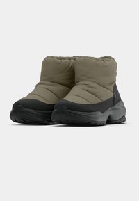 Pufi bokacsizmák, olívazöld textil felsőrésszel és fekete gumitalppal, barázdált talppal a jó tapadás érdekében, valamint rugalmas felső résszel a megfelelő illeszkedésért.