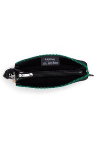 Cartera Kipling de Harry Potter con un interior de tela negra, cremallera verde y un pequeño llavero de mono. Dos compartimentos, uno con cremallera.