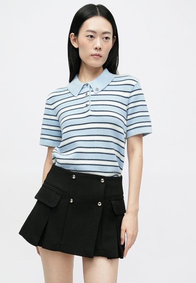Blau-weiß gestreifte kurzärmlige Poloshirt mit Kragen, kombiniert mit einem plissierten schwarzen Rock mit silbernen Knöpfen und Taschen.