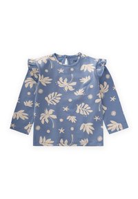 Plava bluzica dugih rukava s bijelim cvjetnim i zvjezdastim uzorkom. Ruffles na ramenima. Ima okrugli izrez i zatvaranje na dugme na leđima.