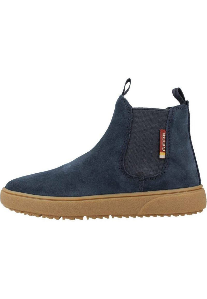 Zilā suede Chelsea botas ar elastīgu sānu paneļa, gumijas zoli un vilkšanas cilpu. Iespējas ar teksturētu apdari un kontrastējošu gumijas zoli.