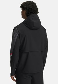Schwarze leichte Kapuzenjacke mit farblich abgesetzten Ärmeln in Grau und roten Akzenten. Verfügt über einen lässigen Schnitt und ein mehrlagiges Rückendesign.