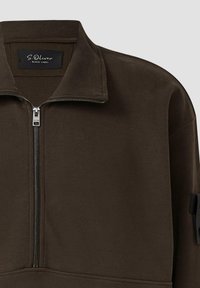 Ciemnobrązowy sweatshirt z ćwierć zamkiem i stójką, z widocznym srebrnym zamkiem błyskawicznym oraz metką S.Oliver Black Label wewnątrz kołnierza.