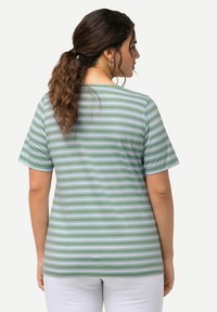 Polo w paski w kolorze zielonym i jasnoniebieskim, krótki rękaw, okrągły dekolt, miękki materiał, luźny krój, widoczne szwy na plecach.