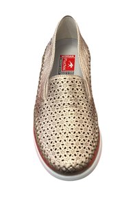 Zapato slip-on dorado perforado con punta redonda, parte superior texturizada y suela de goma blanca realzada por un acento rojo.