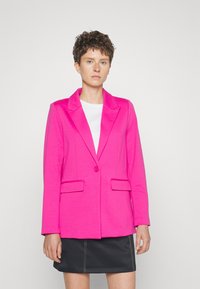 Skinnende rosa blazer med spiss krage, enkelt knapp, og to frontlommer. Stofet har en jevn tekstur og en tettsittende design.
