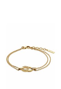 Bracciale in tono oro con due catene collegate. Presenta un ciondolo ovale con pietre trasparenti e un piccolo tag inciso "JETTE."