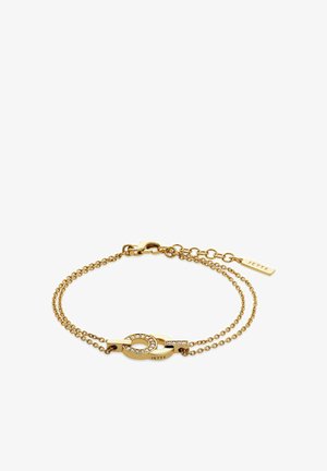 Bracciale in tono oro con due catene collegate. Presenta un ciondolo ovale con pietre trasparenti e un piccolo tag inciso "JETTE."