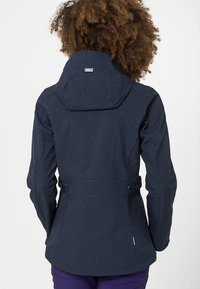 Giacca in blu navy, con texture, con cappuccio, vita regolabile e design sfiancato sul retro. Presenta cuciture visibili e un piccolo logo sulla parte posteriore.