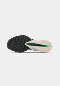 Semelle de chaussure Nike Flyplate avec un design en caoutchouc texturé noir, des accents menthe verte et un détail rose sur la semelle intermédiaire, présentant une rainure centrale.