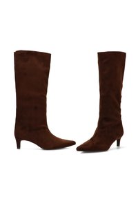 Botas de ante marrón hasta la rodilla con punta afilada y tacón bajo. Textura suave con una silueta elegante. Sin herrajes o acentos visibles.