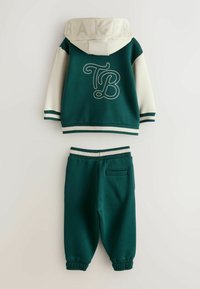 Chándal de dos piezas en verde y crema que incluye una sudadera con capucha con "BAKER" en la capucha y el logo "TB", además de pantalones ajustados a juego.