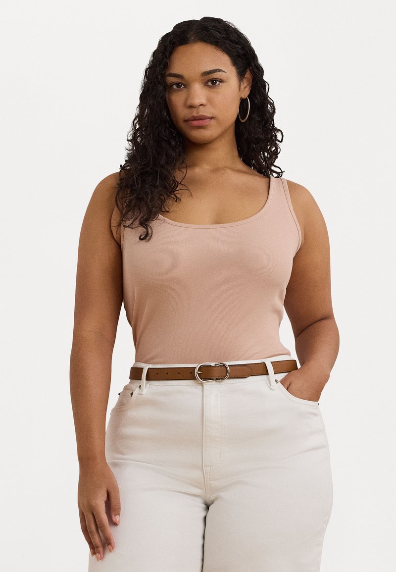 Ljusrosa ribbad linne med rundad halsringning, kombinerat med högmidjade krämfärgade byxor och ett brunt bälte med en silverfärgad spänne.