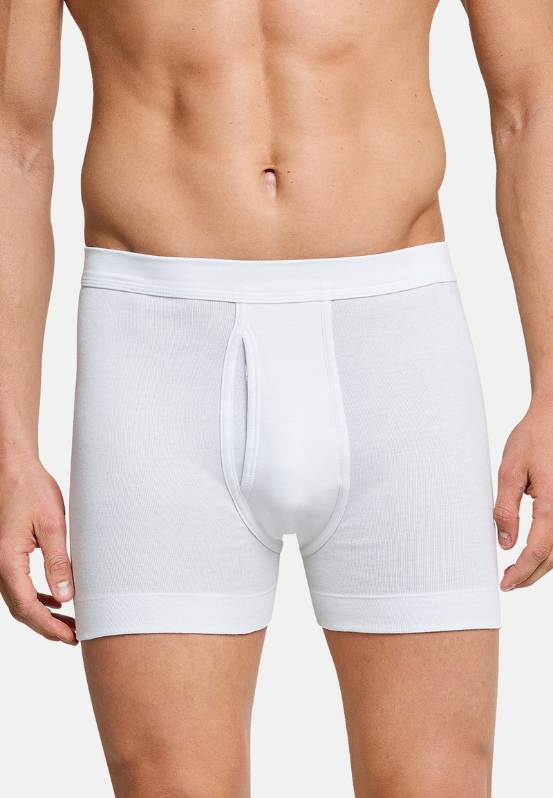 Boxer briefs bianchi in cotone con una texture liscia, dotati di un'apertura frontale e una vestibilità aderente. Il cinturino è elasticizzato e a coste.