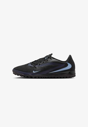 Zapatilla deportiva negra de Nike con logos swoosh azules, parte superior texturizada, cordones y suela de goma diseñada para césped artificial o juego al aire libre.
