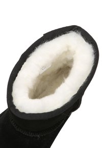 Schwarze Wildlederstiefel mit strukturiertem Äußeren und einem weißen, weichen Kunstfellfutter am oberen Rand. Verfügt über genähte Nähte und ein geschwungenes Oberdesign.