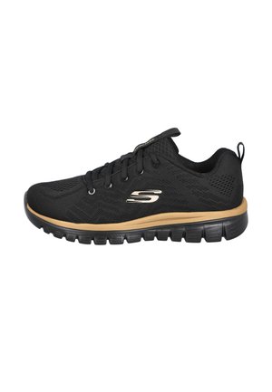 Zapato deportivo negro con entresuela beige, suela negra, cordones en la parte delantera, parte superior de malla y logo plateado "S" en el lateral.