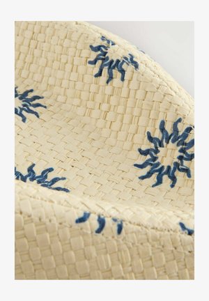 Cesta tejida con una textura de color crema, que presenta patrones florales bordados en azul y un borde suave y curvado.