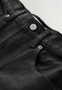 Jeans in denim nero caratterizzati da una texture liscia, accessori metallici e un classico design a cinque tasche, con cuciture visibili e chiusura a bottone.