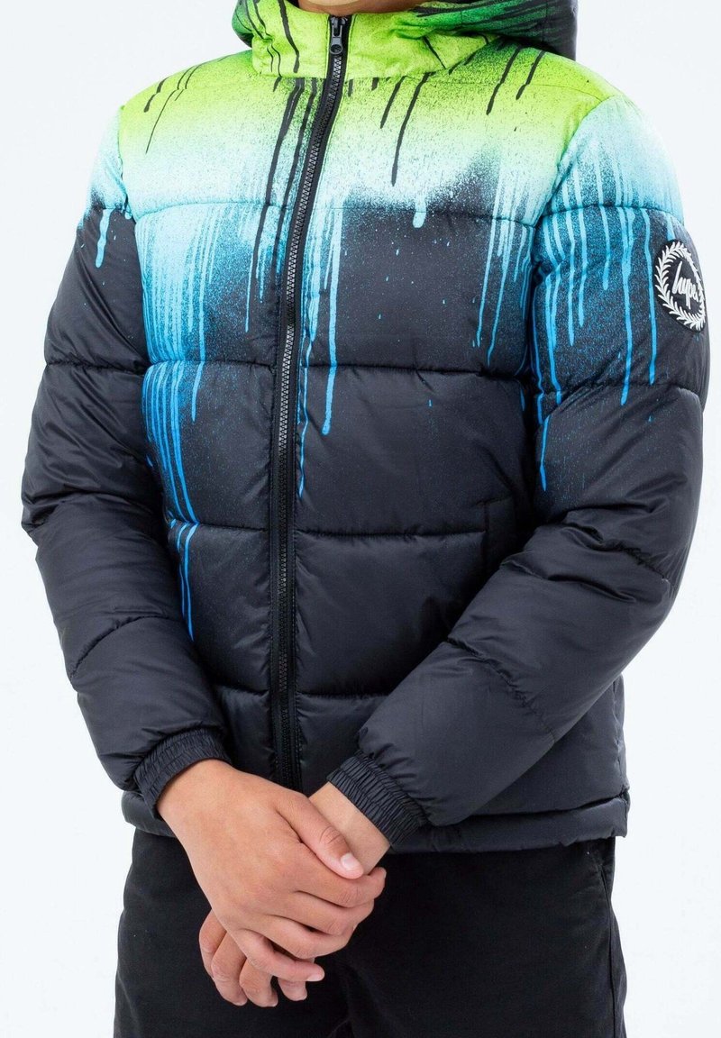 Zwarte pufferjas met een gradient ontwerp, voorzien van groene en blauwe verf druppels. Rits aan de voorkant, ribbelmanchetten, logo op de mouw.