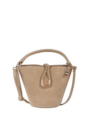 Sac seau en daim beige avec une poignée arrondie, une bandoulière ajustable, un nœud décoratif, un anneau en or et un petit pendentif drapeau italien.