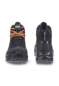Schwarze Wanderschuhe mit orangen Schnürsenkeln, einer strukturierten Oberseite, gepolstertem Schaft und einer robusten Gummisohle mit einem gemusterten Profil für besseren Grip.