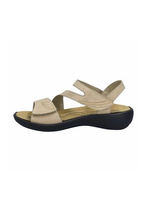 Beige sandal with a perforated design, adjustable straps, cushioned insole, and a black platform sole.