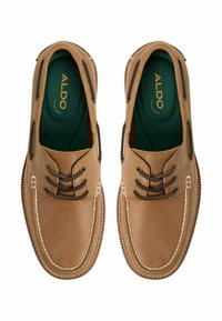 Bruna läderskärgårdsskor med rundad tå och kontrasterande beige sömmar. Har mörkbruna skosnören och en grön innersula med varumärkets logotyp.