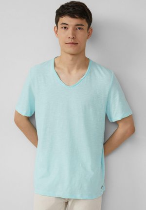 Helles Blau, kurzärmliges V-Ausschnitt-T-Shirt aus weichem, strukturiertem Stoff; lockere Passform mit einem subtilen Glanz. Minimale Markenkennzeichnung am Saum.
