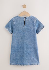 Džinsinė suknelė trumpomis rankovėmis, šviesiai mėlynos spalvos, apvalia iškirpte, su raktu atverčiamu atlošu nugaros dalyje ir kontrastingomis siūlėmis apačioje.