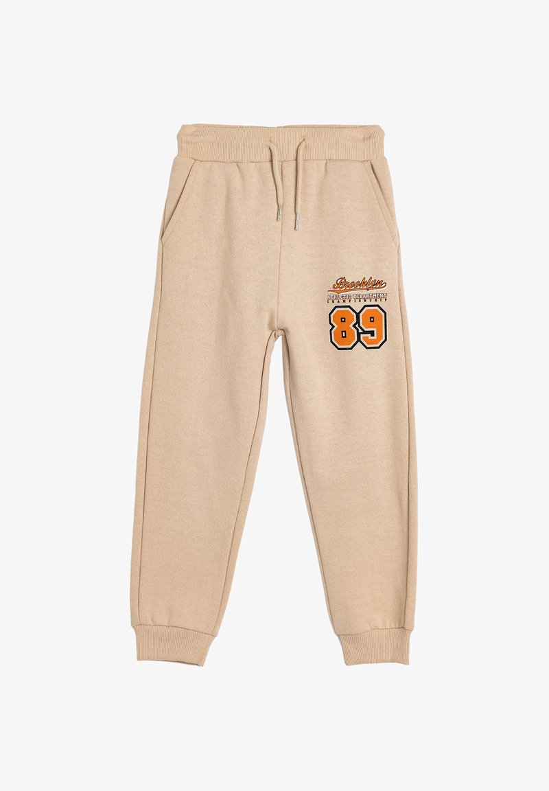 Beige sweatpants made of soft fabric, featuring an elastic waistband, side pockets, and printed design with "Brooklyn" and the number "89."