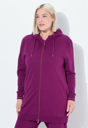 Violetti vetoketjuhuppari, jossa on huppu, pitkät hihat, raidoitetut hihansuut ja hieman pidempi helma. Valmistettu pehmeästä puuvillasekoitekankaasta.