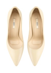 Bottines en cuir crème à bout pointu avec une texture lisse, un talon arrondi et une couture le long du bord. L'intérieur est beige.