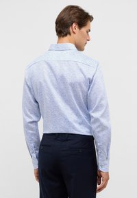 Lichtblauw patroonhemd met lange mouwen en knoopmanchetten, voorzien van een subtiel paisleypatroon en een klassieke kraag.