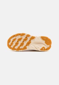 Suela de zapatilla de running con una superficie beige texturizada y acentos de goma naranja. Presenta un diseño segmentado para tracción y flexibilidad.