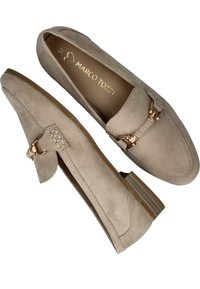 Beige Wildleder-Mokassins mit niedrigem Blockabsatz. Mit dekorativem goldenen Hardware-Akzent und gestickten Details auf dem Obermaterial. Innere Markenkennzeichnung sichtbar.