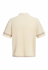 Polo en maille à manches courtes couleur crème avec texture en maille et bordure beige discrète sur les manches et l'ourlet, vu de dos.