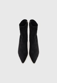 Stivaletti neri in suede con punta affusolata, dotati di chiusura con zip sul retro e una texture liscia. Senza motivi visibili o dettagli in metallo.