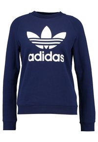 Sweatshirt bleu marine à manches longues, avec col et poignets côtelés. Présente un grand logo Adidas blanc et un design à trois bandes.