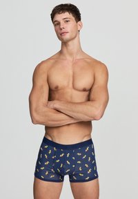 Boxer shorts blu navy con un motivo colorato e ripetuto di piccoli pesci cartoni animati. Realizzati in cotone elasticizzato, con una comoda vita elasticizzata.