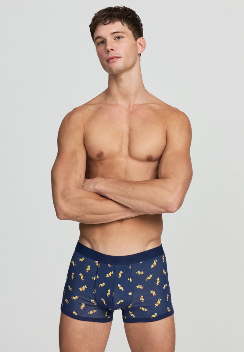Boxer shorts blu navy con un motivo colorato e ripetuto di piccoli pesci cartoni animati. Realizzati in cotone elasticizzato, con una comoda vita elasticizzata.