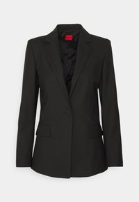 Blazer noir ajusté avec une fermeture à un bouton, des revers crantés, deux poches avant et une doublure intérieure texturée. L'étiquette indique "HUGO".