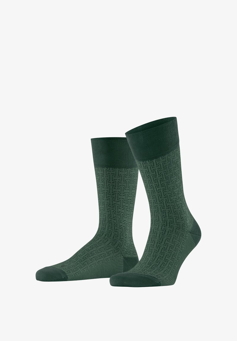 Paire de chaussettes vertes mi-mollet avec un motif géométrique texturé et des sections unies au niveau des orteils, du talon et du bord-côte.