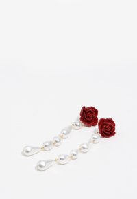 Pendientes florales de rosas rojas que presentan un hilo de cuentas blancas similares a perlas, alternando en tamaño, con acentos dorados entre ellas.